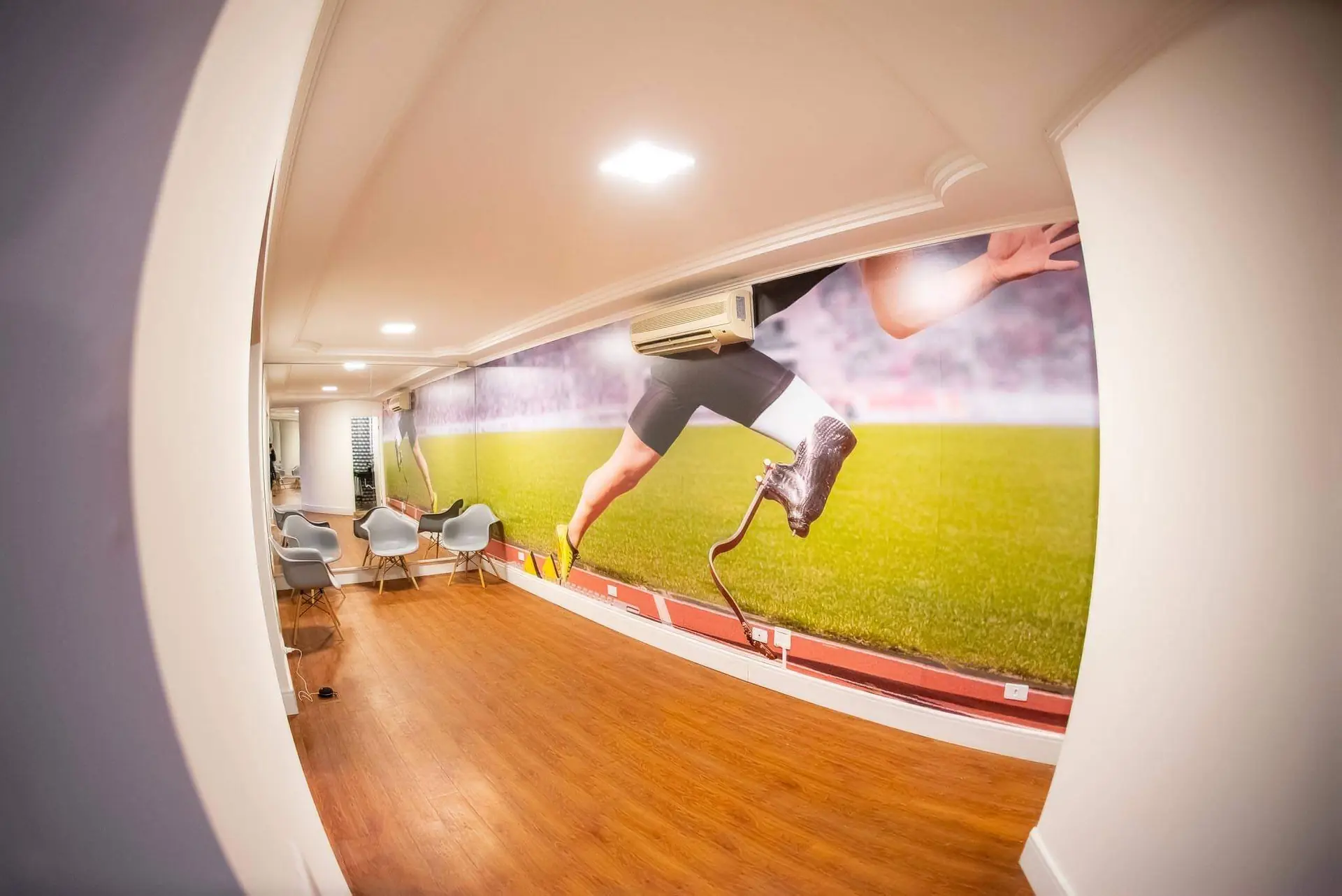 Área de espera da Conforpés com mural de atleta paralímpico