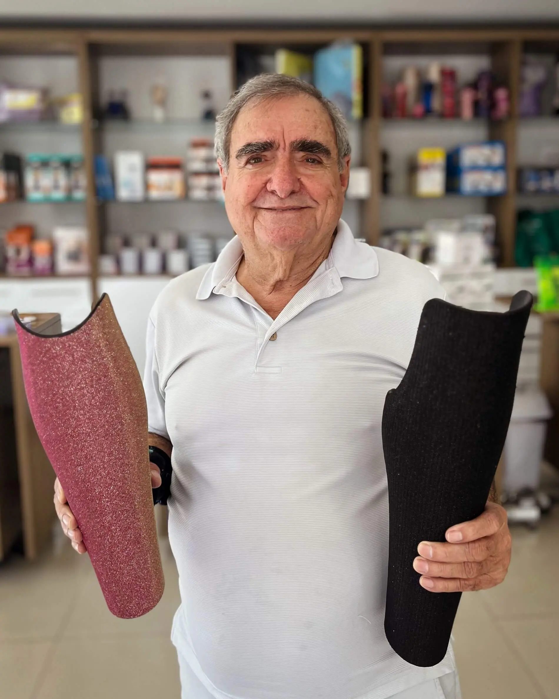 Nelson Nolé, fundador da Conforpés, segurando dois encaixes de prótese